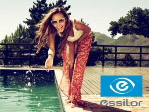 woman wearing trendy sunglasses, laughing, playing with water at pool