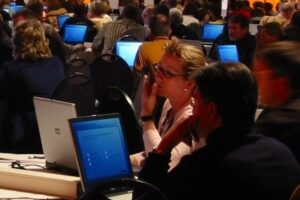 Participants at medical education congress check polling results at tablets