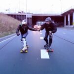 Early Morning in Amsterdam, two guys on skateboards town by an Opel Adam car