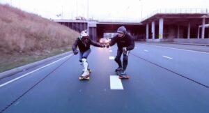 Early Morning in Amsterdam, two guys on skateboards town by an Opel Adam car