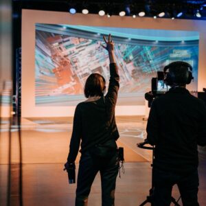 Video livestream director in studio with hand up counting down for action